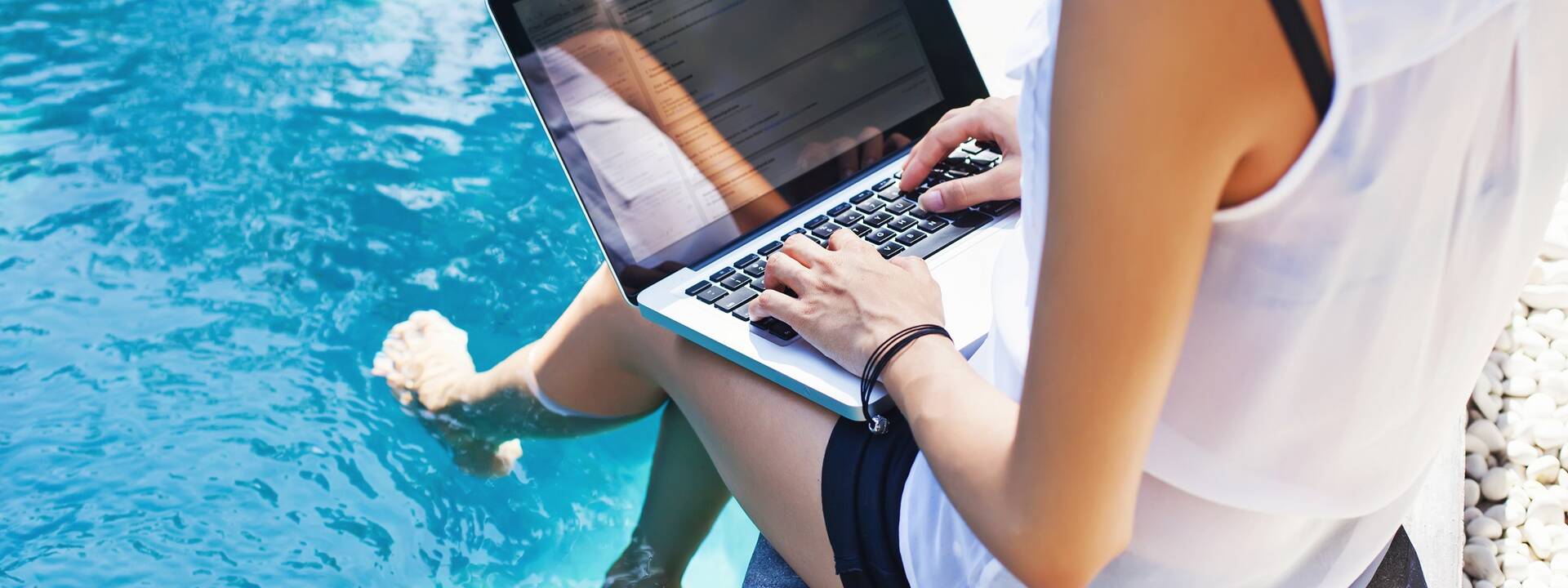 Personne travaillant au bord d'une piscine - ©Shutterstock